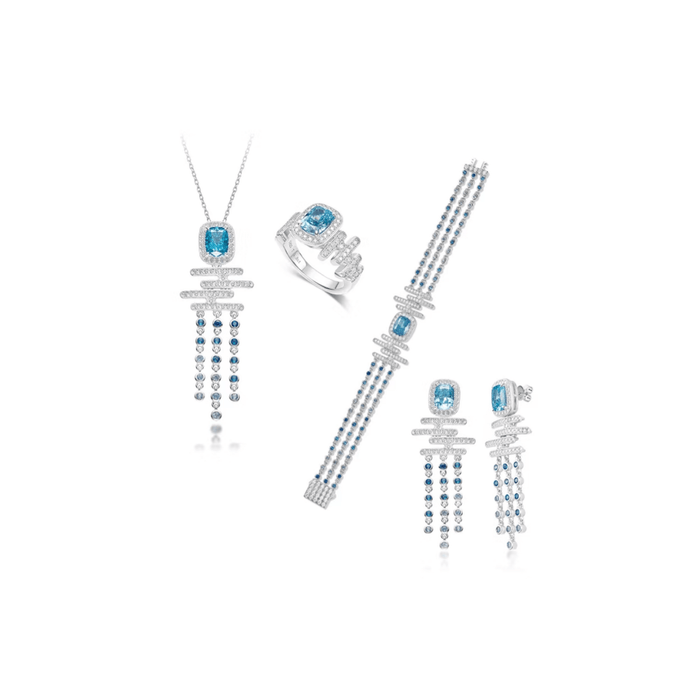 The Cadence Cascade Bracelet by Gem Vivi is part of a matching jewelry set, featuring cushion-cut blue gemstones and white stones set in 18k white gold alongside a necklace, ring, and earrings.