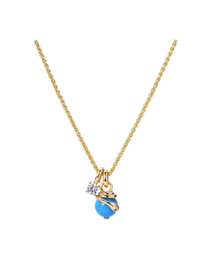 The Serpentine Charm Necklace by Gem Vivi features a gold chain with a blue bead pendant, small clear gemstone, and gold accents, displayed on a white background.