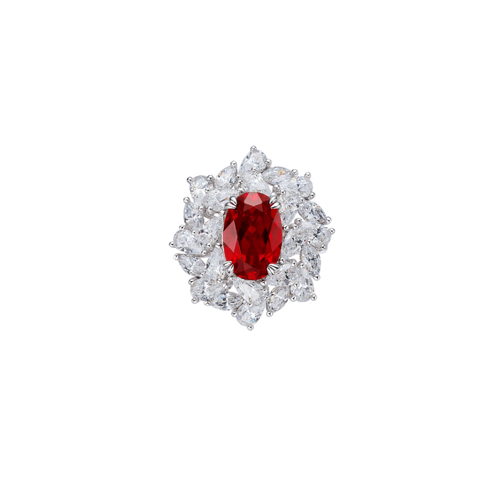 The Blossom Ruby Ring by Gem Vivi features a lab-created oval red ruby, encircled by clear teardrop and round-cut diamonds, all set in an elegant 18k white gold band.