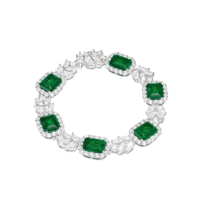 The Emerald Cube Bracelet by Gem Vivi features 18k white gold with alternating large rectangular emerald green stones and sparkling clusters of clear, faceted gems in an intricate design.