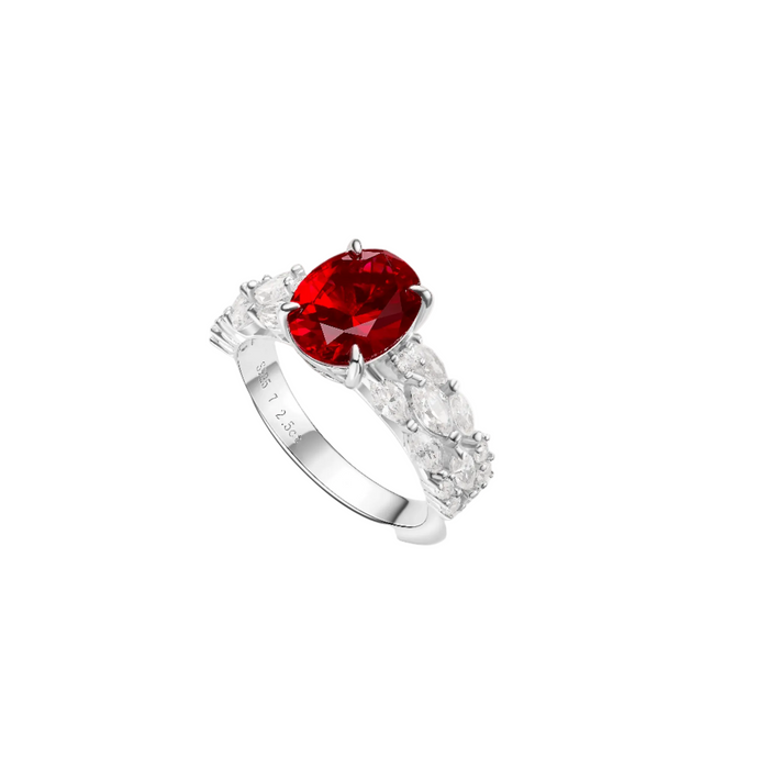 The Celeste Scarlet Ruby Solitaire Ring by Gem Vivi showcases a striking oval-cut ruby centerpiece in 18k white gold, accented with sparkling marquise and round stones along the band.