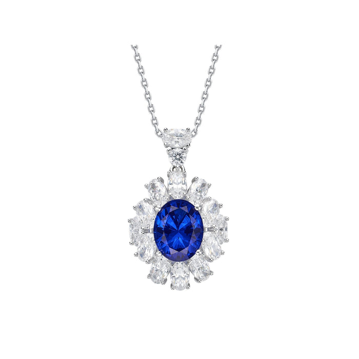 The Gem Vivi Bloom Royal Halo Pendant Necklace is a silver piece with an oval lab-created sapphire and a floral halo of clear, marquise-cut stones.