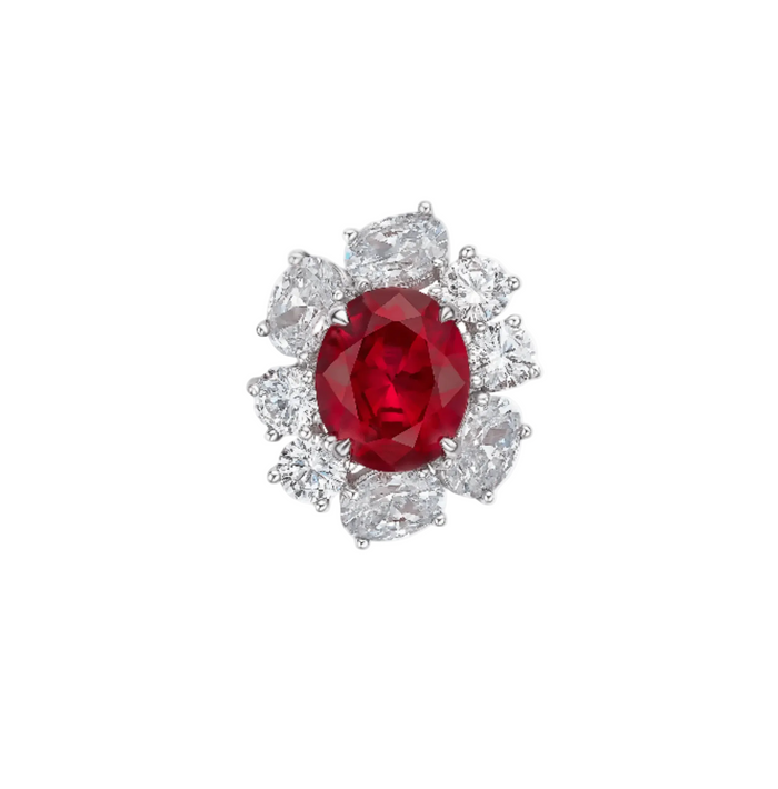 The Cynthia Ruby Spark Solitaire Ring by Gem Vivi showcases a lab-created oval ruby, accented with six pear-shaped and two round clear gemstones in a floral design on 18k white gold.