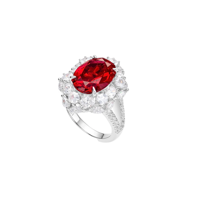 The Celina Scarlet Oval Ruby Ring by Gem Vivi features a striking lab-created oval ruby, surrounded by clear stones and sparkling accents, all set on an 18k white gold band.