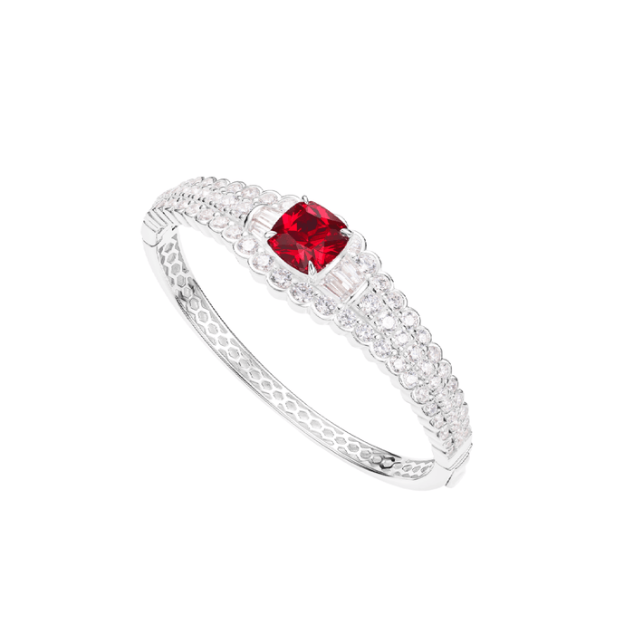 The Clara Square Ruby Bangle Bracelet by Gem Vivi features a cushion-cut ruby centerpiece encircled by clear stones in an intricate sterling silver setting.