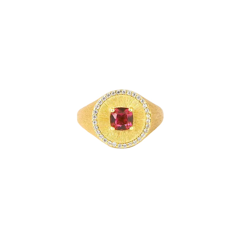 The Ivy Signet Ring by Gem Vivi features 18K yellow gold with a cushion-cut red center stone, surrounded by small clear stones, shown on a white background.