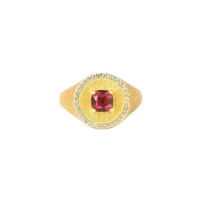 The Ivy Signet Ring by Gem Vivi features 18K yellow gold with a cushion-cut red center stone, surrounded by small clear stones, shown on a white background.