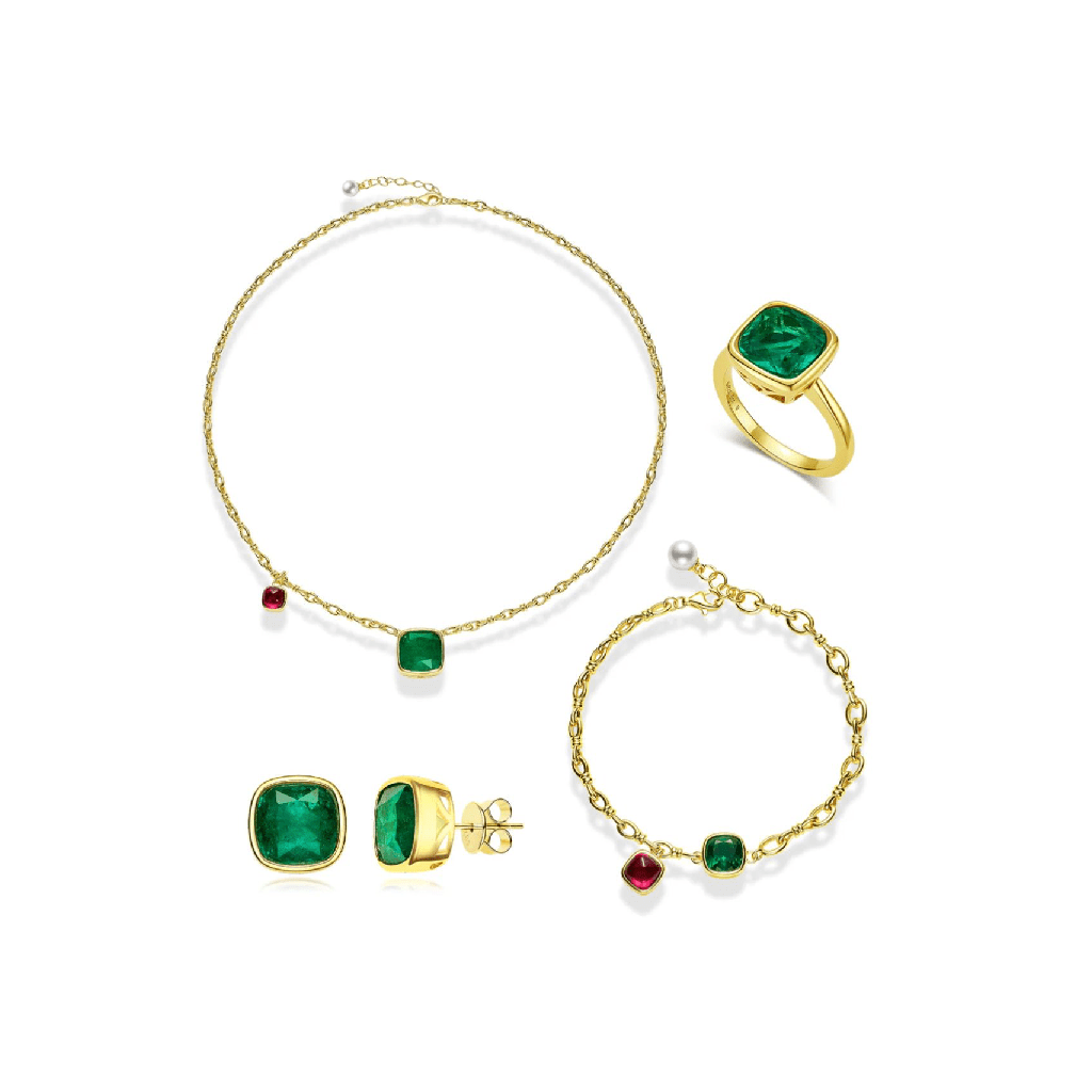 The Chloe Emerald Glow Cushion Studs by Gem Vivi, crafted in 18k yellow gold with green gemstones and red accents, are displayed on a white background as part of a gold jewelry set with a necklace, ring, and bracelet.