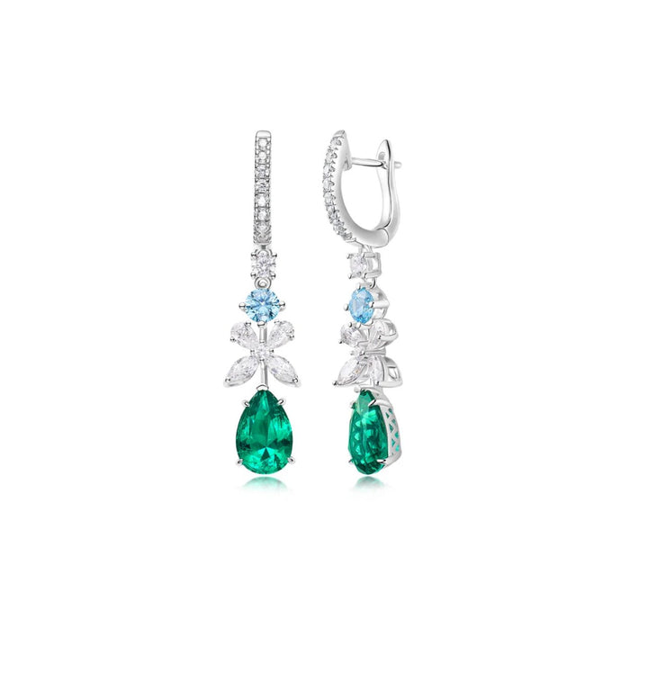 The Emerald Cascade Harmony Drop Earrings from Gem Vivi showcase green teardrop lab-created emeralds, blue round stones, and clear marquise and round gems set in 18k white gold.