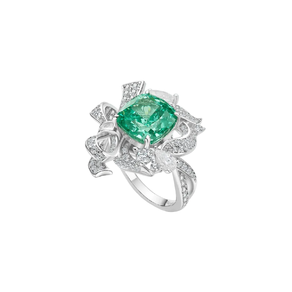 The Gem Vivi Enchanted Garden Paraiba Ring showcases a cushion cut green gemstone in 18k white gold, accented with ribbon-like details and sparkling clear stones.