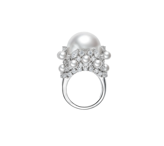 The Carina Luminous Pearl Ring by Gem Vivi showcases a large Australian white shell pearl set in 18k white gold, accented with smaller pearls and sparkling gemstones in an elegant design.