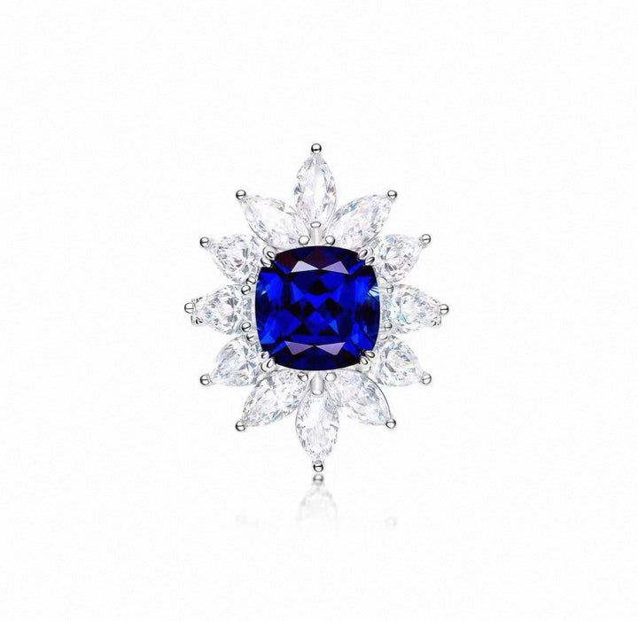 The Gem Vivi Midnight Starburst Sapphire ring showcases a large cushion-cut sapphire center, framed by two rows of marquise-cut clear stones in a striking floral sunburst design.