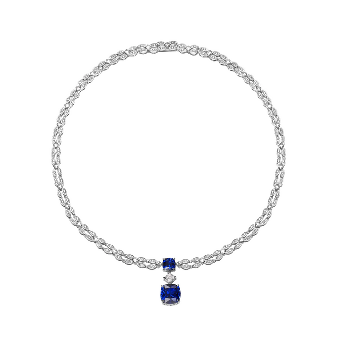 The Gem Vivi Blue Ocean Depths Necklace features a diamond-accented chain and a pendant with a white gemstone set above a larger blue gemstone.