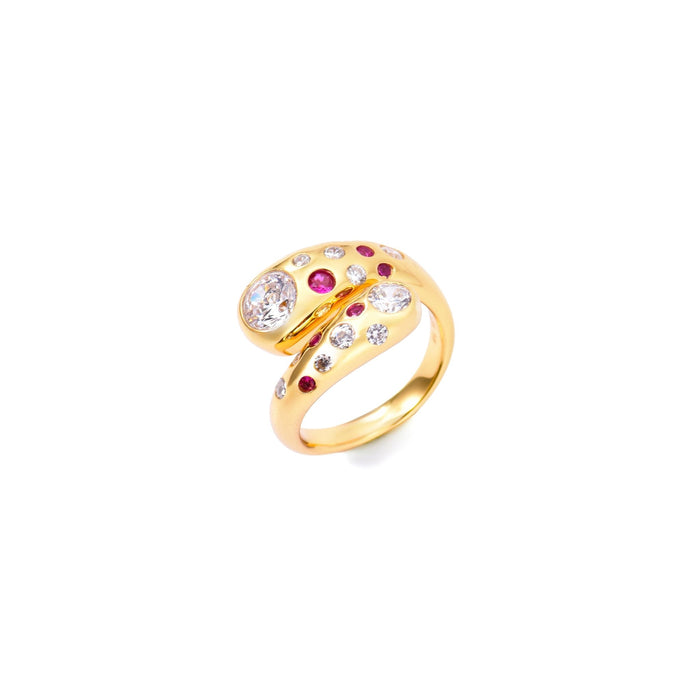 The Gem Vivi Pomegranate Red Wrap Ring features a unique wraparound design in 18k yellow gold with a large clear cubic zirconia and multiple small pink and clear stones set along the band.