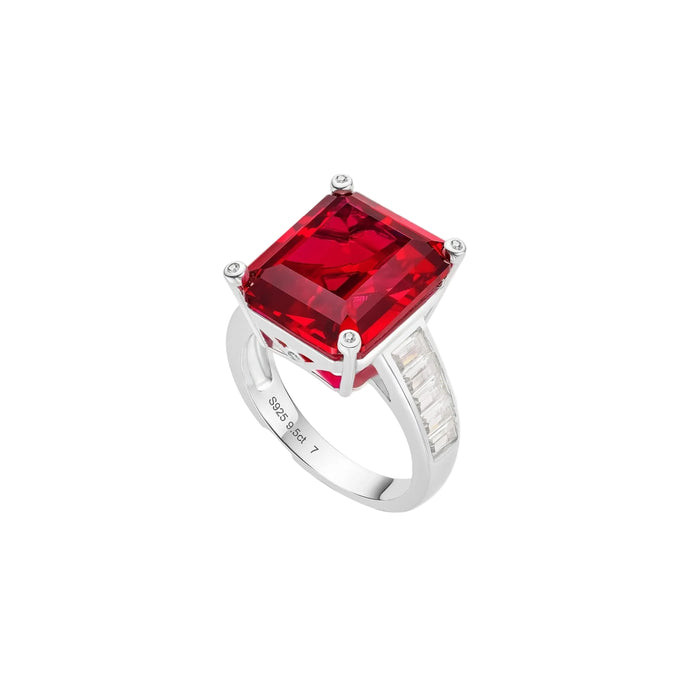 The Ruby Luxe Solitaire Ring by Gem Vivi is a silver cocktail ring with a large rectangular red gemstone in four prongs and baguette-cut clear stones on the band—a perfect statement piece to elevate any look.