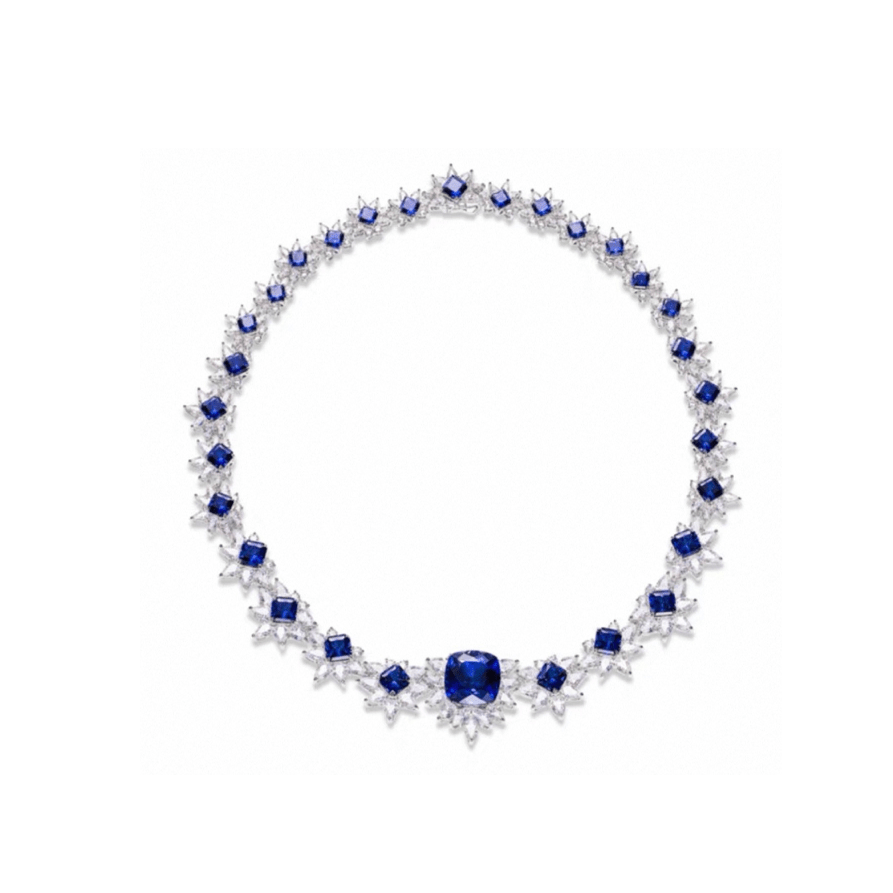 The Gem Vivi Midnight Starburst Necklace features alternating blue sapphires and clear diamonds in a symmetrical 18k white gold setting, highlighted by a central cushion cut sapphire.