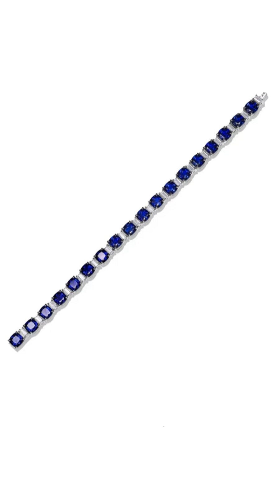 The Gem Vivi Blue Sapphire Tennis Bracelet showcases a row of cushion-cut lab-created sapphires set in individual silver links.