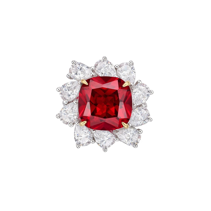 The Cyra Radiance Ruby Cushion Ring by Gem Vivi showcases a square-cut ruby accented with pear-shaped clear stones in a circular halo, all set in 18k white gold.